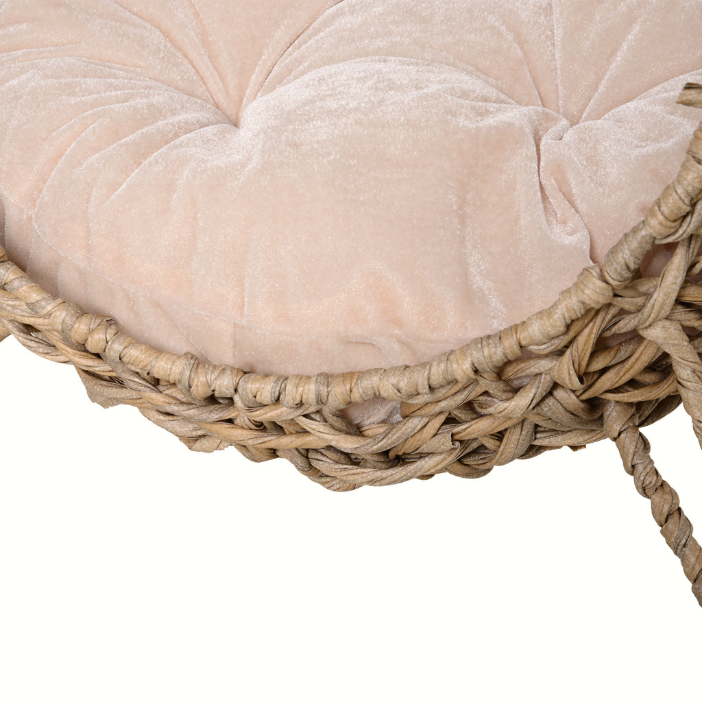 Close-up of the plush removable cushion inside the woven elevated cat bed