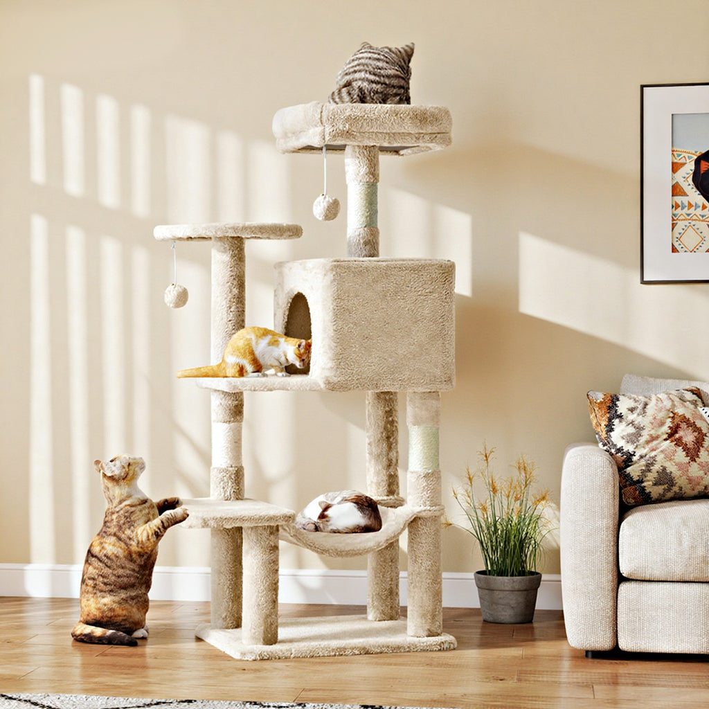 Cats playing on the beige Haven cat tree in a living room